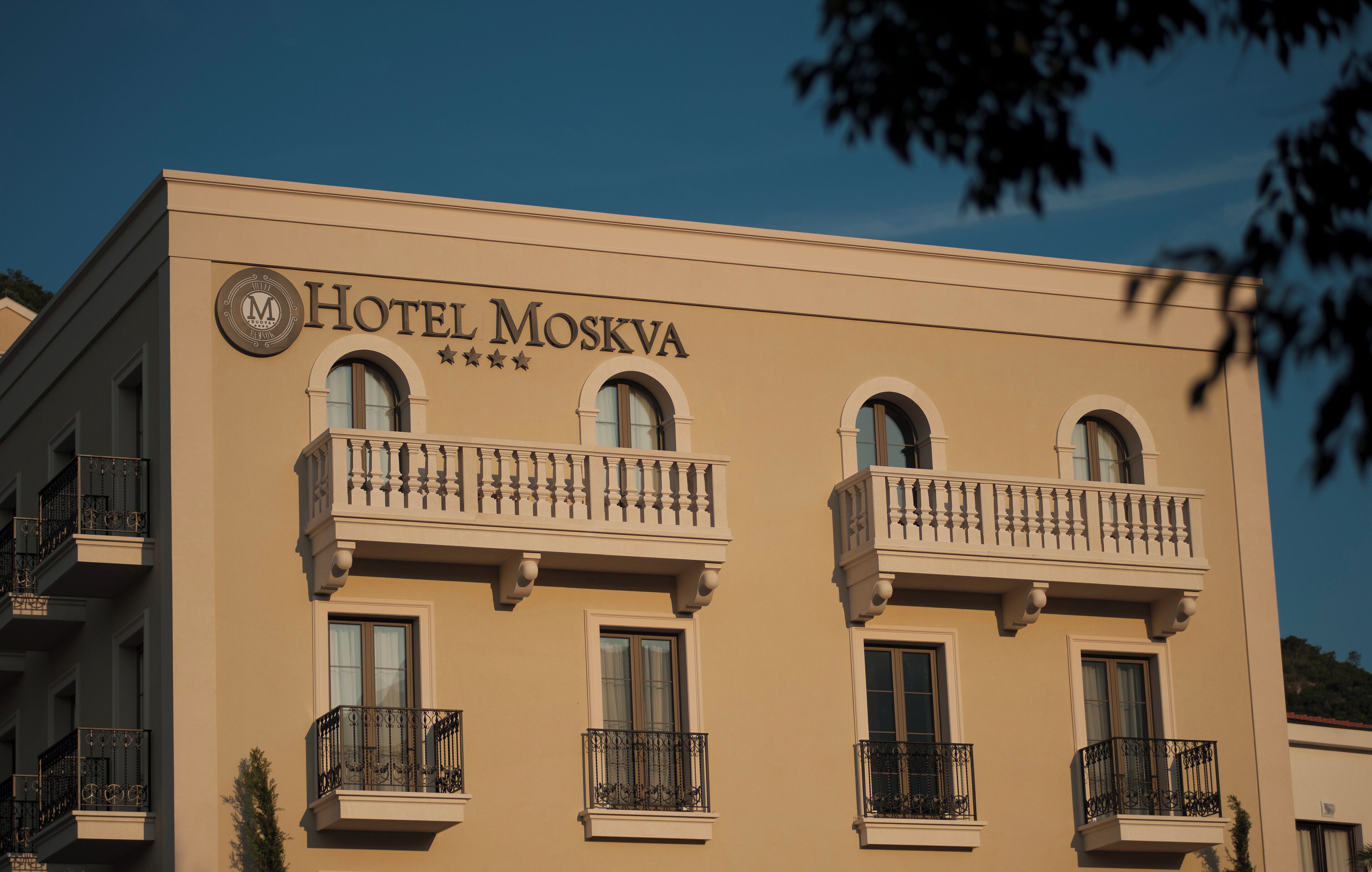 A building with the sign "Hotel Moskva" and multiple balconies with black railings.