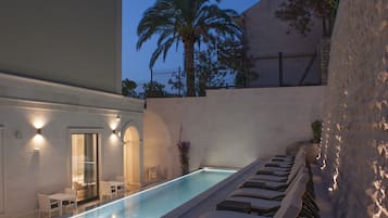 Alberca al aire libre y camastros