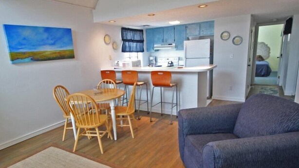 Un espace de vie compact comprenant un coin repas, une kitchenette et un canapé.