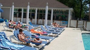 A poolside area with lounge chairs and a covered seating area. - Lake Arrowhead Quarters (Myrtle Beach)