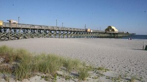 A pier extending into the water with a large dome structure at the end. - Lake Arrowhead Element (Myrtle Beach)