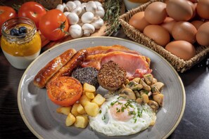 A breakfast plate with sausages, eggs, tomatoes, and mushrooms. - Clayton Hotel Cambridge (Cambridge)