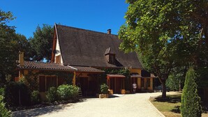 A traditional house with a tiled roof, a chimney, and a gravel driveway leading to a wooden door. - Les Plantous de Severo (Cenac-et-Saint-Julien)