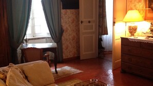 Un salon chaleureux avec un canapé, une commode en bois et une lampe.