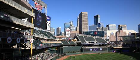 A baseball stadium with multiple levels of seating, a large screen, and advertisements for Pepsi, Mortensen, and Delta.