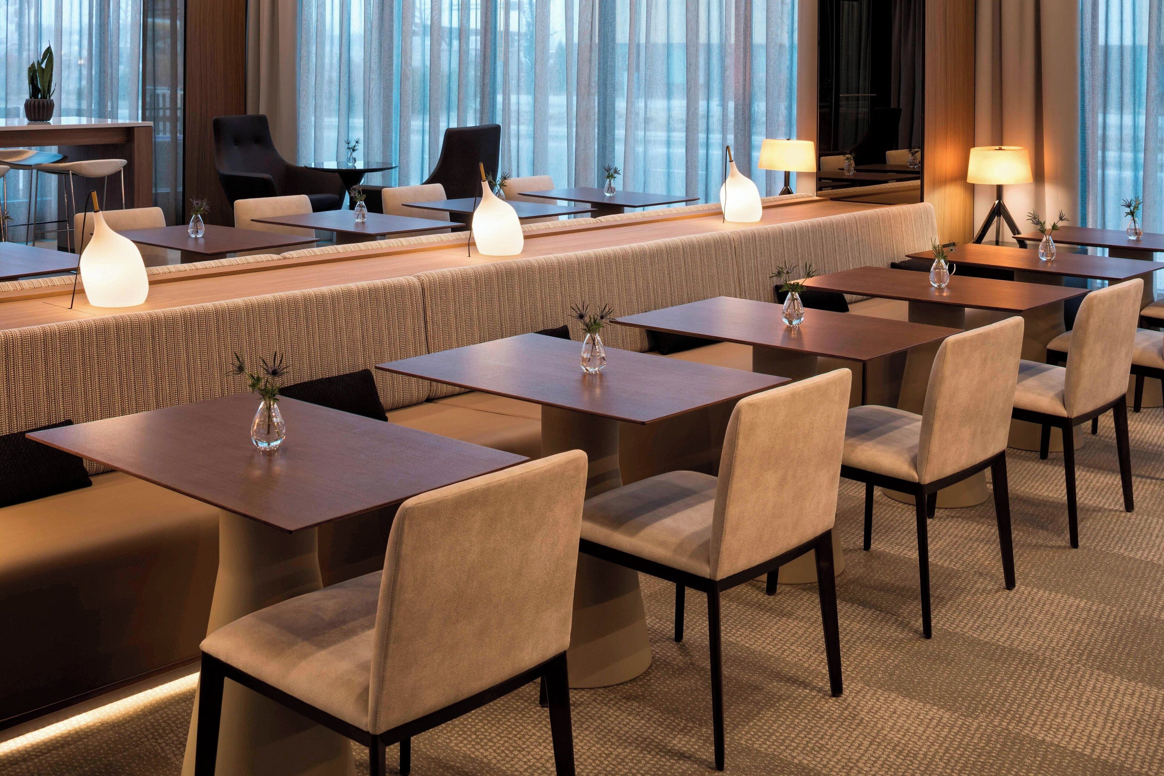 A modern hotel lobby with a long reception desk, comfortable seating, and ambient lighting.