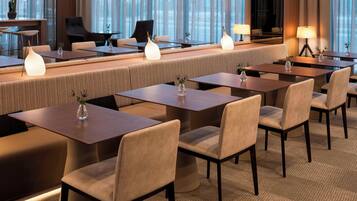 A modern hotel lobby with a long reception desk, comfortable seating, and ambient lighting.