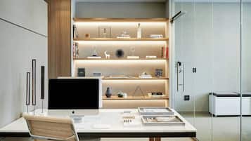 A modern office desk with a computer, books, and decorative items.