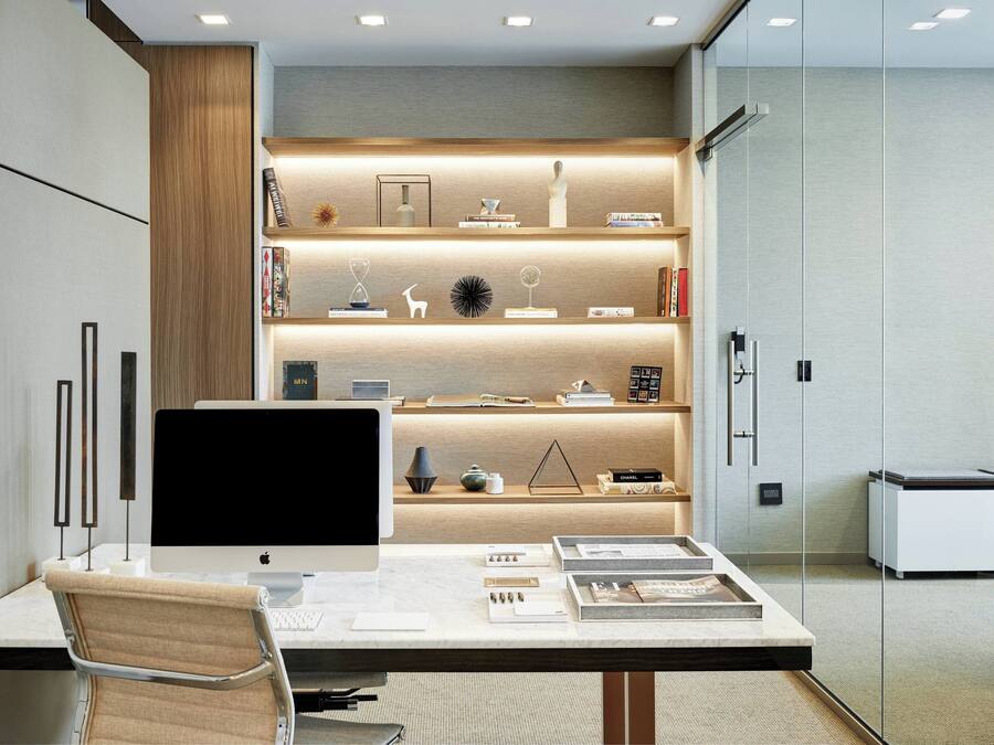 A modern office desk with a computer, books, and decorative items.