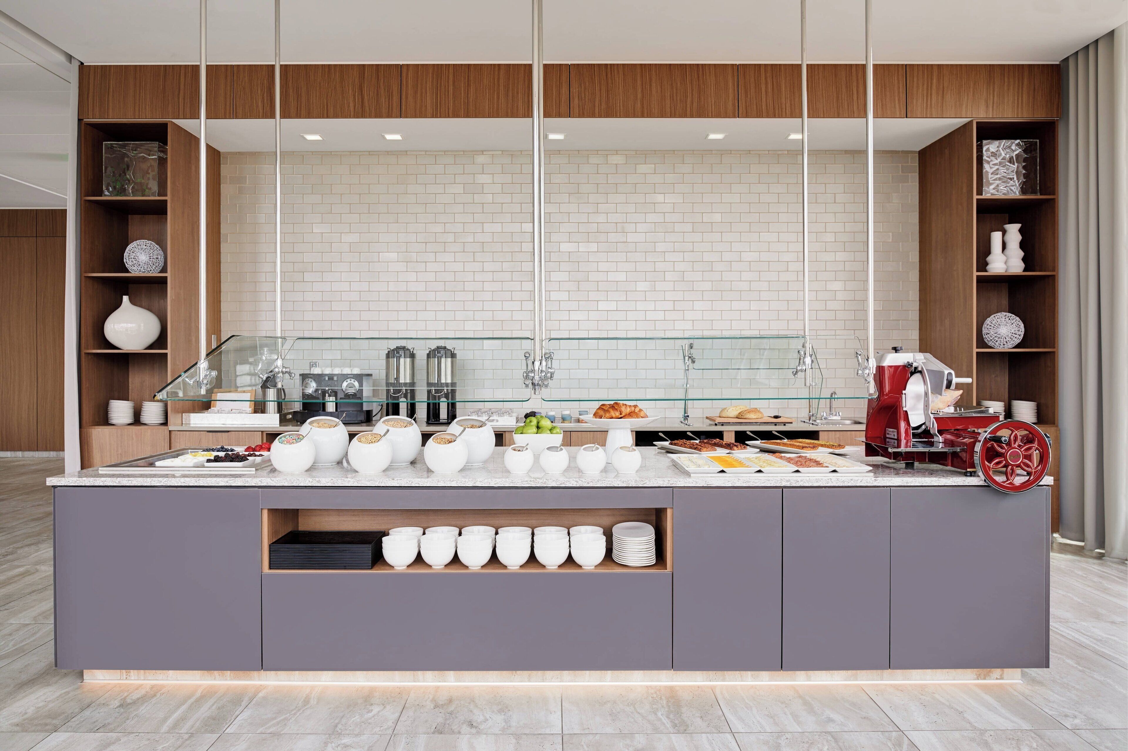 Una barra de desayuno moderna con cerramiento de vidrio, azulejos blancos y detalles de madera.