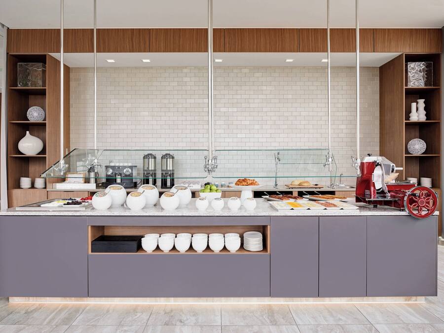 Una barra de desayuno moderna con cerramiento de vidrio, azulejos blancos y detalles de madera.