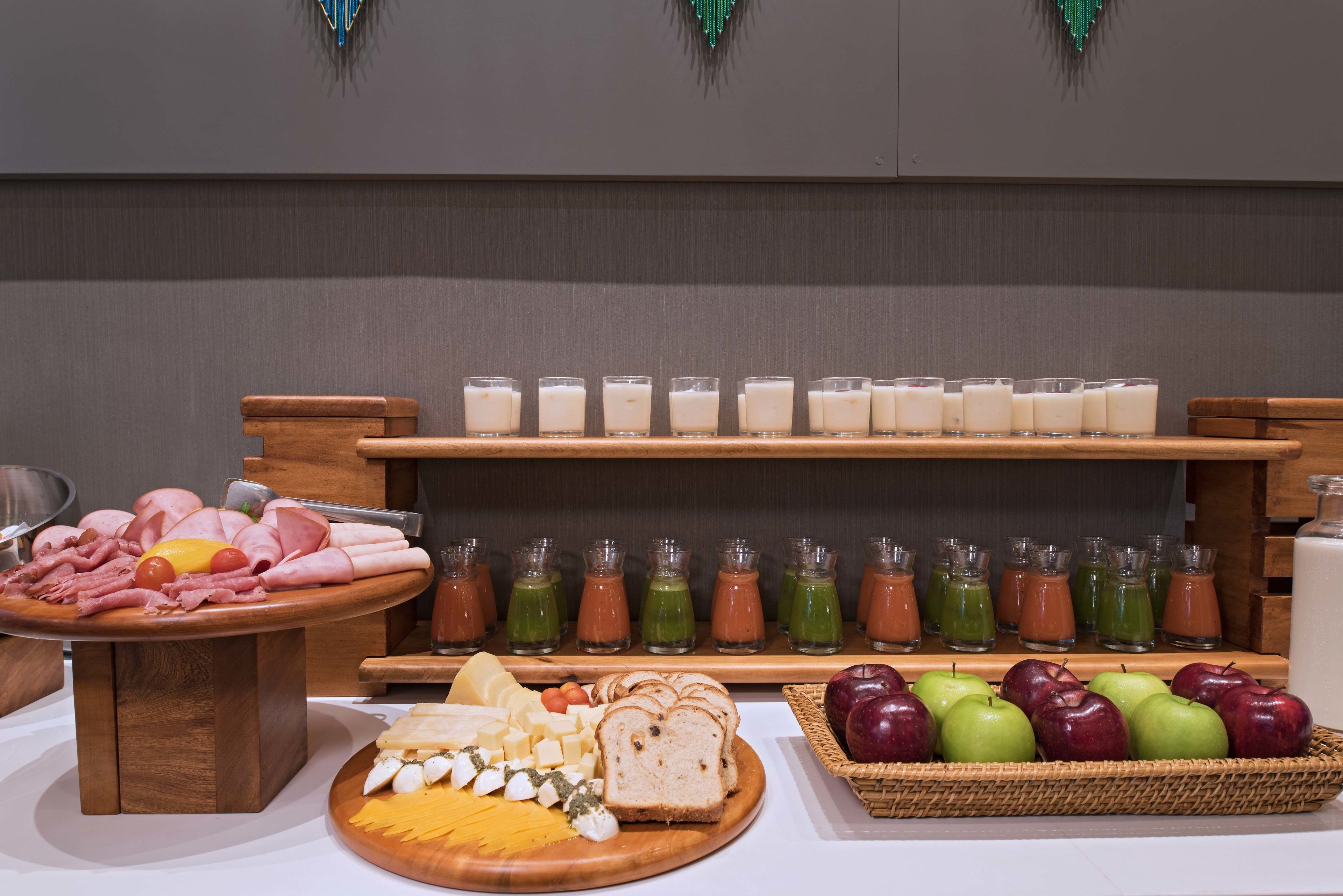 Un buffet proposant une variété de plats, notamment des viandes, des fromages et des fruits.