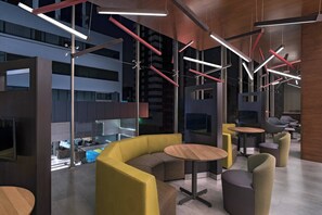 A modern interior with a curved seating area, multiple tables, and contemporary lighting fixtures. - Courtyard by Marriott Guatemala City (Guatemala City)
