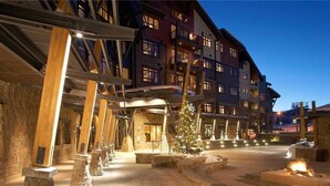 A multi-story hotel with a stone facade, wooden beams, and a central courtyard with a Christmas tree. - Heavenly Peak 310 4 BedroomCondo By Moving Mountains (Steamboat Springs)