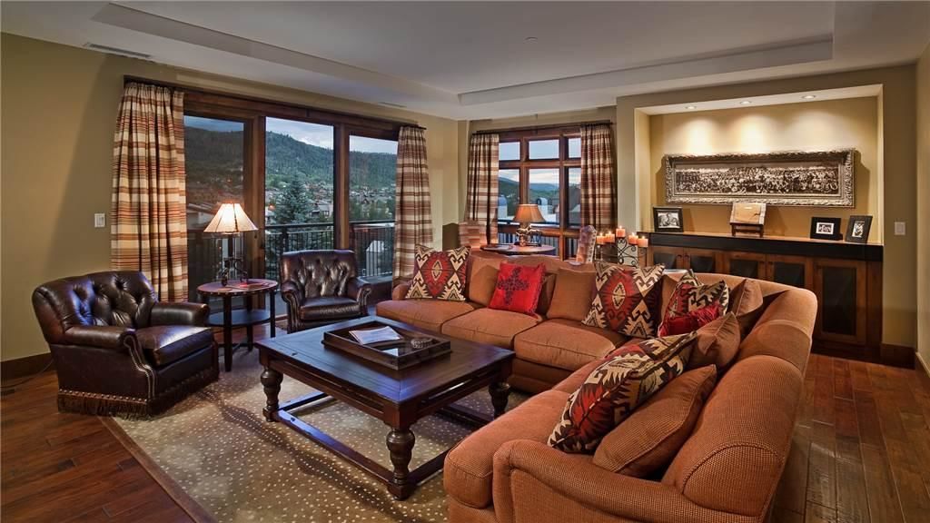 A living room with a sofa, armchairs, a coffee table, and a view of the outdoors.