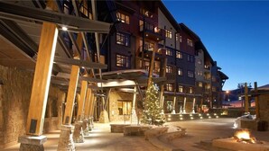A hotel with a stone facade, multiple balconies, and a central courtyard with a Christmas tree.