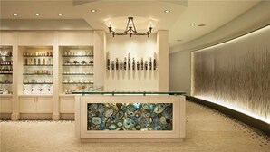 A modern interior with a central display case, shelves with various items, and a decorative wall with a textured pattern. - Zirkel Mountain 419 4 BedroomCondo By Moving Mountains (Steamboat Springs)