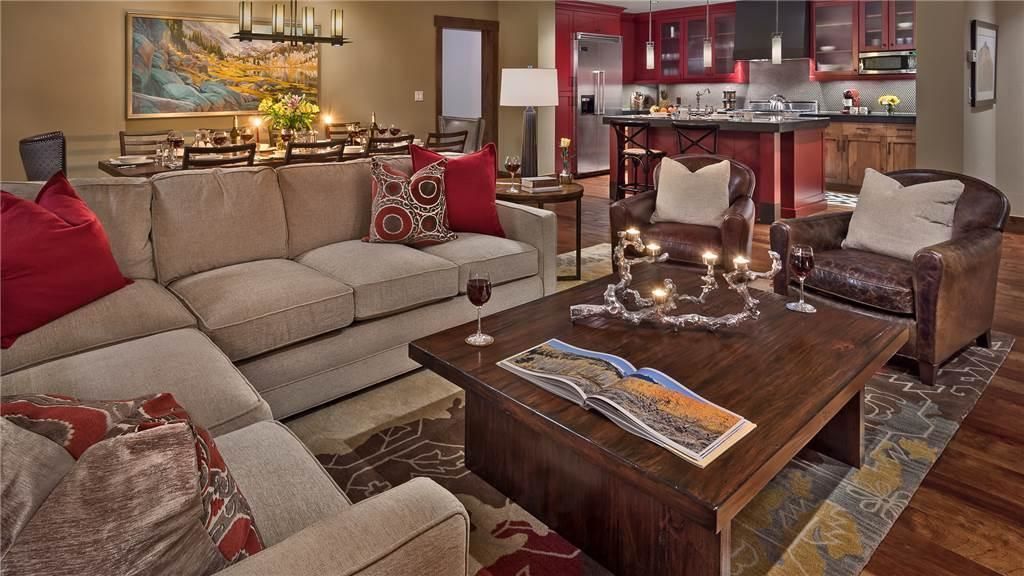 A living room with a sofa, armchairs, a coffee table, and a dining area with a table and chairs.