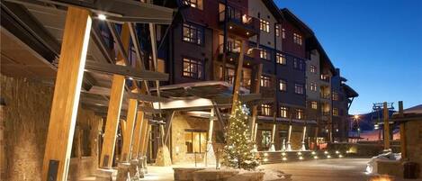 A hotel with a stone facade, multiple balconies, and a central courtyard with a Christmas tree.