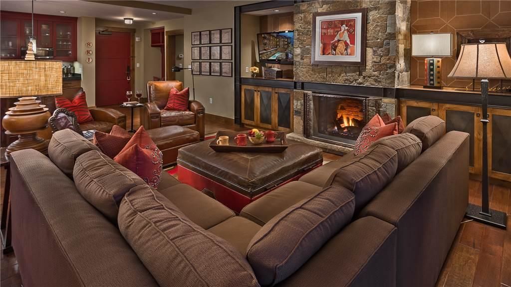 A spacious living room with a fireplace, leather sofas, and a coffee table.