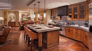 Una cocina amplia con una isla central, armarios de madera y electrodomésticos modernos.