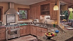 A spacious kitchen with wooden cabinets, a stainless steel stove, and granite countertops.