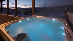 Ein Whirlpool mit Blick auf eine Stadtlandschaft im Abenddämmerung.