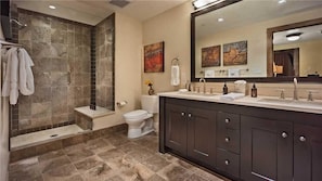 Une salle de bain moderne équipée d’une douche, de toilettes et d’un meuble-lavabo.
