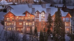 A large, multi-story lodge with a prominent balcony on the second floor, surrounded by snow-covered trees. - Falconhead Lodge North 5 BedroomHoliday home By Moving Mountains (Steamboat Springs)