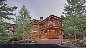 A large, multi-story wooden house with a stone facade, large windows, and a well-maintained garden. - Gold Mine Lodge 6 BedroomHoliday home By Moving Mountains (Steamboat Springs)
