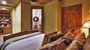 Ein Schlafzimmer mit einem großen Bett, einem Holzschrank und einem Bücherregal.