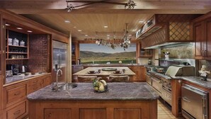 Une cuisine spacieuse avec des meubles en bois, un plan de travail en granit et un grand îlot central.