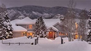 Ein zweistöckiges Haus vor einer verschneiten Landschaft.