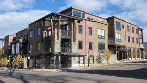 A multi-story building with a brick facade, large windows, and a ground-level commercial space.