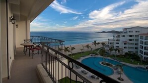 Un balcón con vistas al océano y a una piscina.