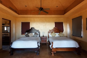 A bedroom with two wooden beds, a ceiling fan, and a nightstand between them. - Casa Vida Home 4 Bedroom Villa By Seaside Los Cabos (San José del Cabo)