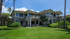 A large, two-story house with a spacious front yard, a covered patio, and a balcony. - Palm Villa 126B (Kailua-Kona)
