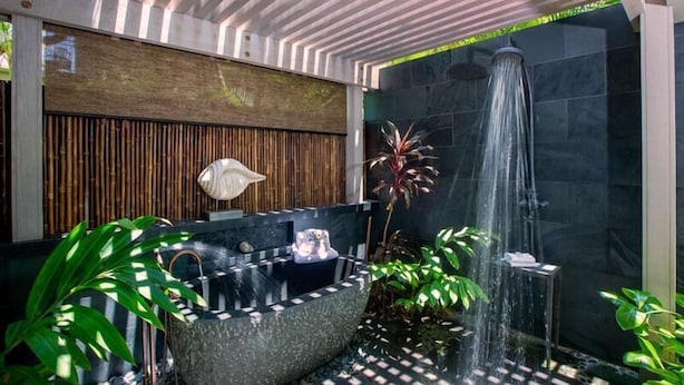 A modern bathroom with a freestanding bathtub, a shower, and a bamboo wall. - Palm Villa 126B (Kailua-Kona)