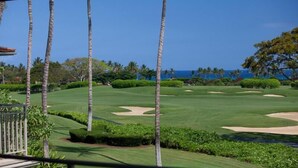 A golf course with a view of the ocean and palm trees. - 120A Waiulu Street Hualalai (Kailua-Kona)