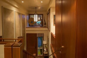 A wooden staircase with a handrail, a window with a view, and a ceiling light fixture. - 129B Hualalai (Kailua-Kona)
