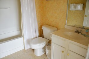 A bathroom with a toilet, sink, and mirror. - 1523 The Havens (North Myrtle Beach)