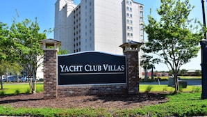 A sign for "Yacht Club Villas" with a brick base and a black background. - 1805 Yacht Club Villas (North Myrtle Beach)