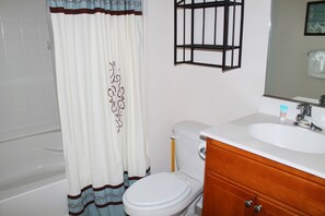 A bathroom with a toilet, sink, and shower curtain. - 1623 Willow Bend (North Myrtle Beach)