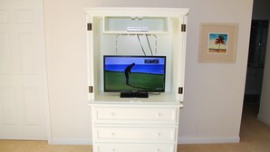 A white entertainment center with a flat-screen TV displaying a golf game. - 223 Willow Bend (North Myrtle Beach)