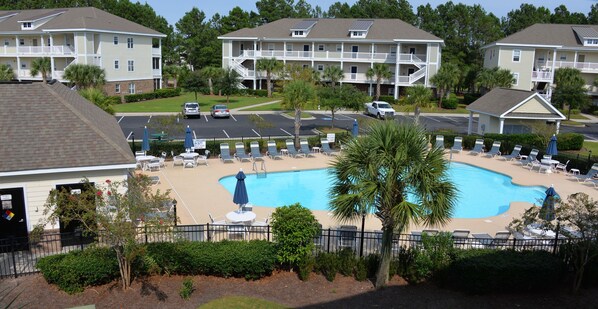 Relax by the resort's central pool surrounded by lounge chairs and umbrellas.
