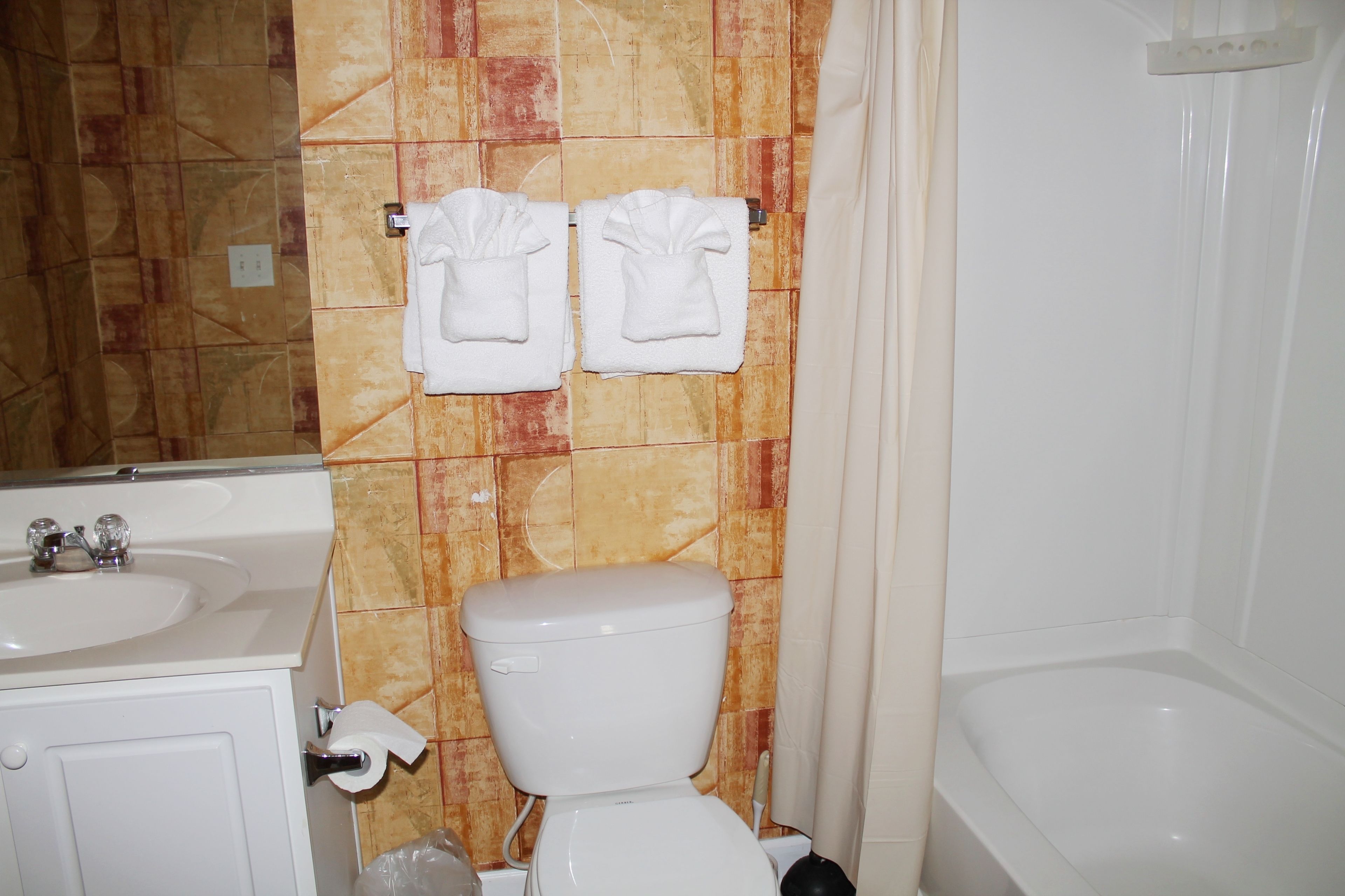 A bathroom with a toilet, sink, and bathtub.