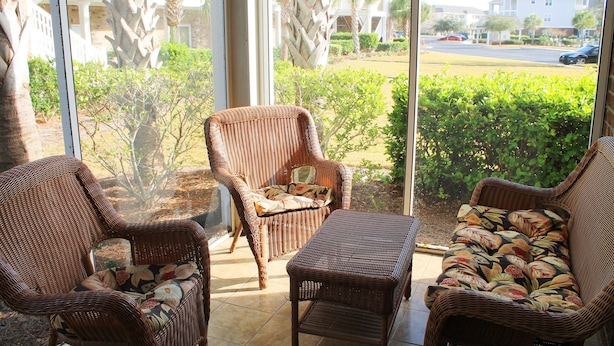 A wicker-furnished balcony with a view of a residential area. - 614 Willow Bend (North Myrtle Beach)