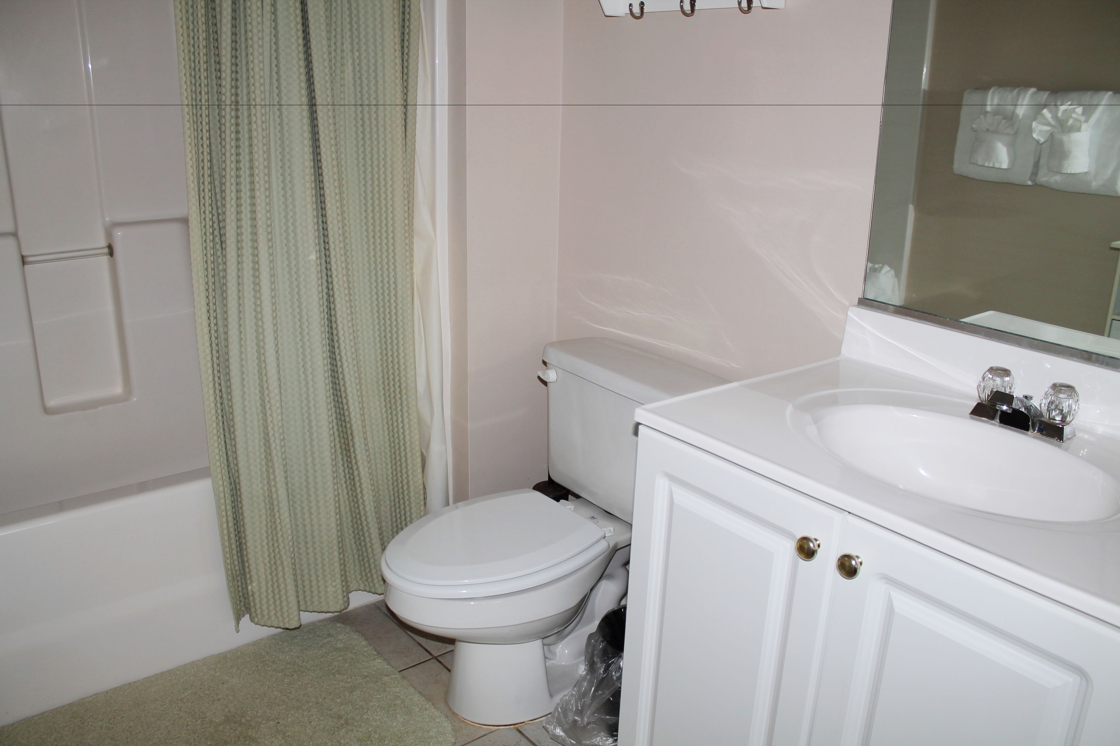 Een badkamer met toilet, wastafel en douche.