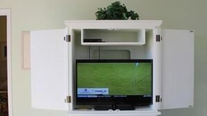 A white entertainment unit with a flat-screen TV displaying a sports game. - 1321 The Havens (North Myrtle Beach)