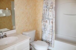 A bathroom with a toilet, sink, and shower. - 1321 The Havens (North Myrtle Beach)